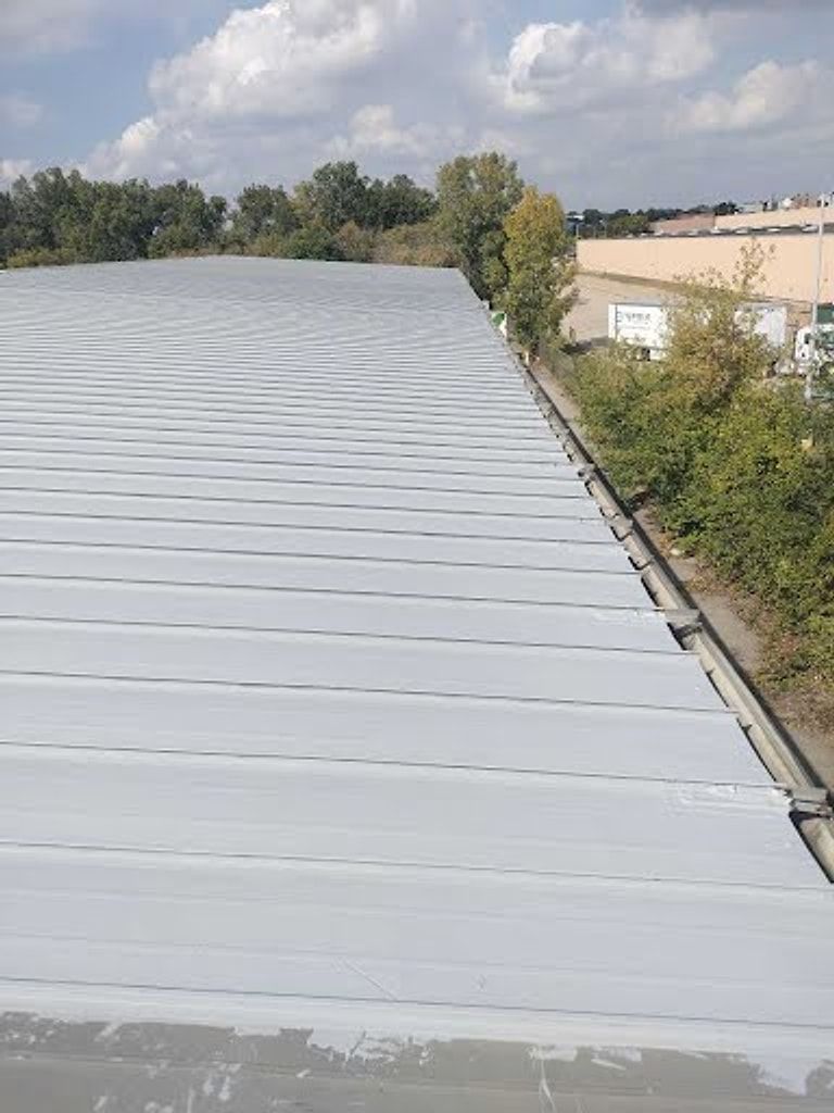 Long metal roof finished with a white roof coating
