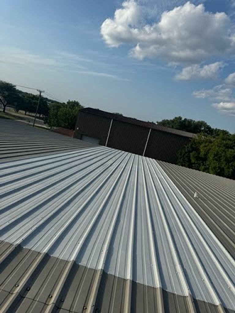 Ribbed metal roof on a commercial building under a blue sky